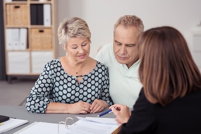 Picture of a Carer helping an elderly person working on a laptop